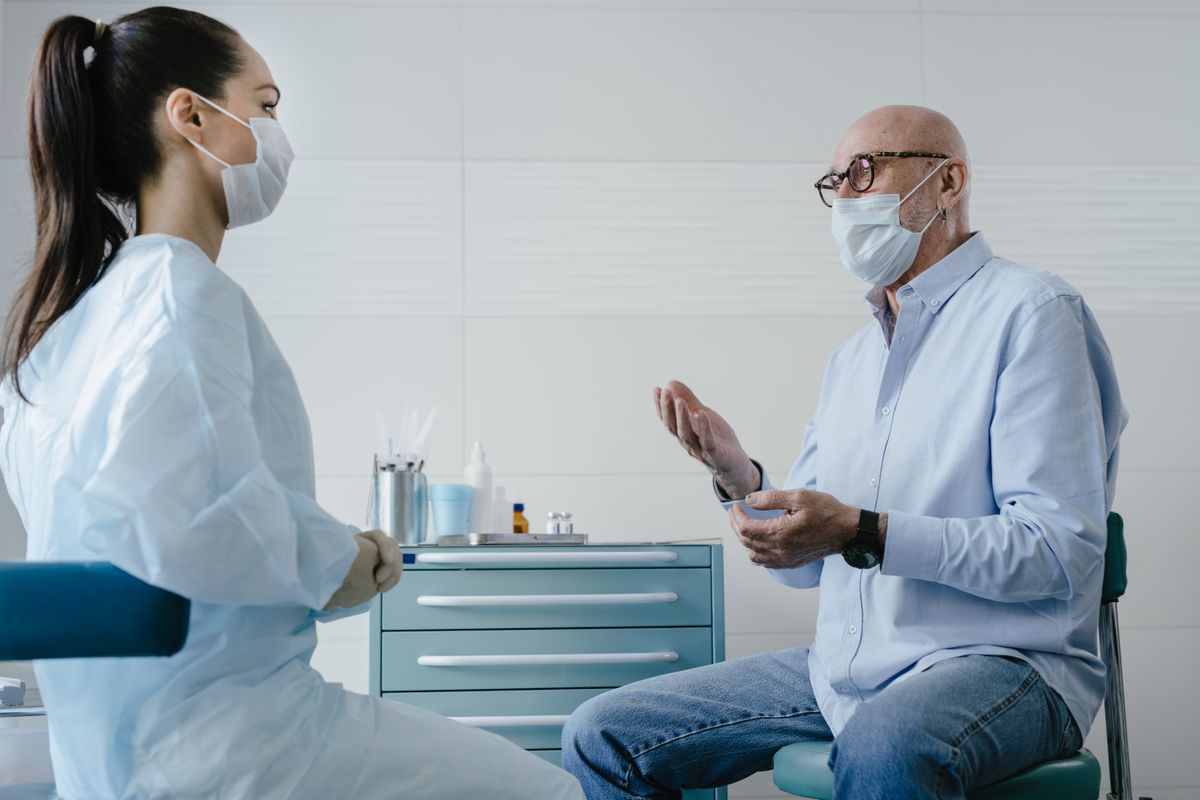 Doctor listening to an elderly patient describe symptoms