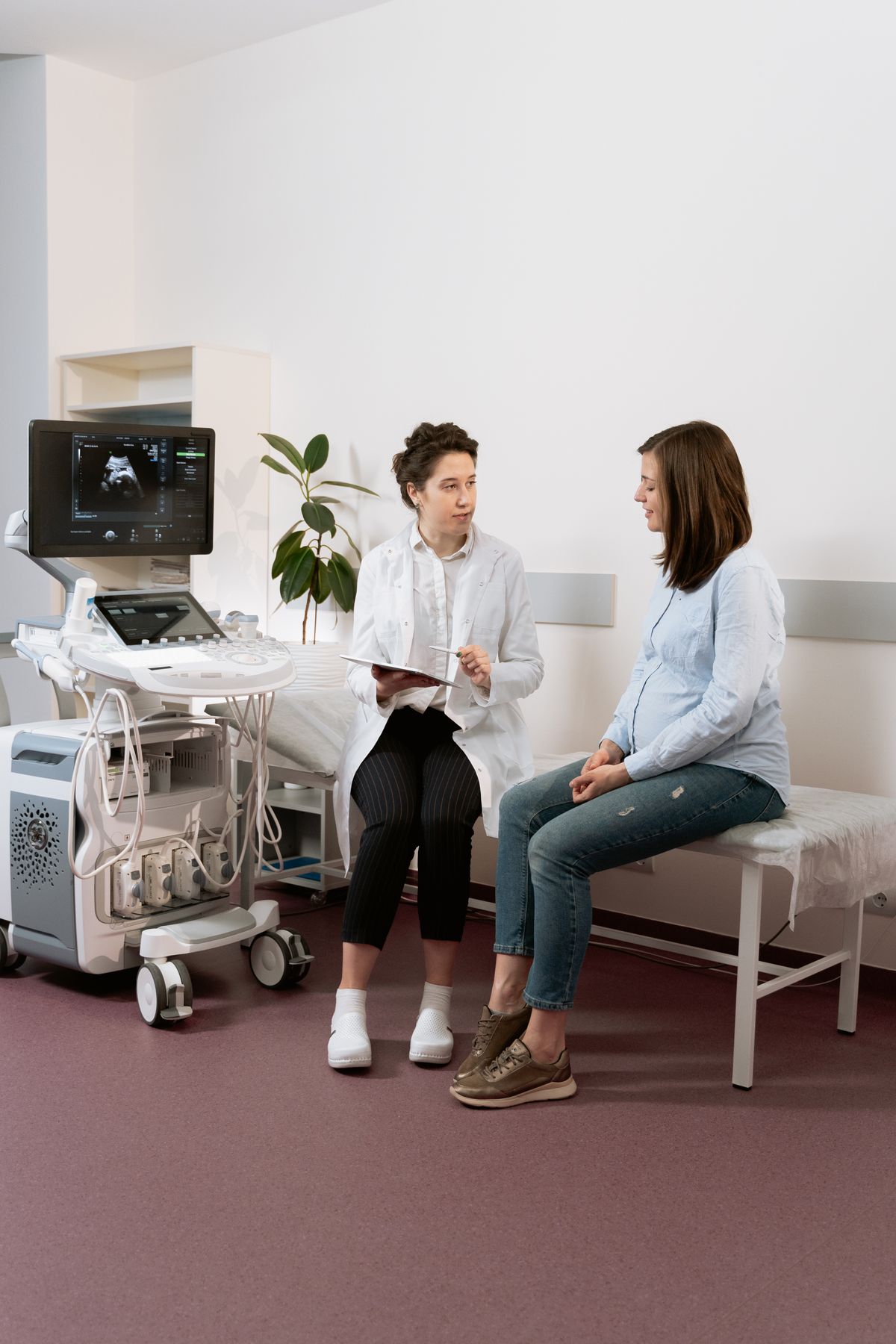 Doctor reviewing an antenatal scan on a monitor with a patient