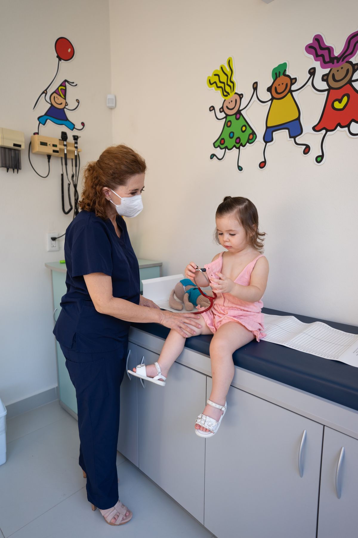 Doctor standing beside a little girl in a pediatric office