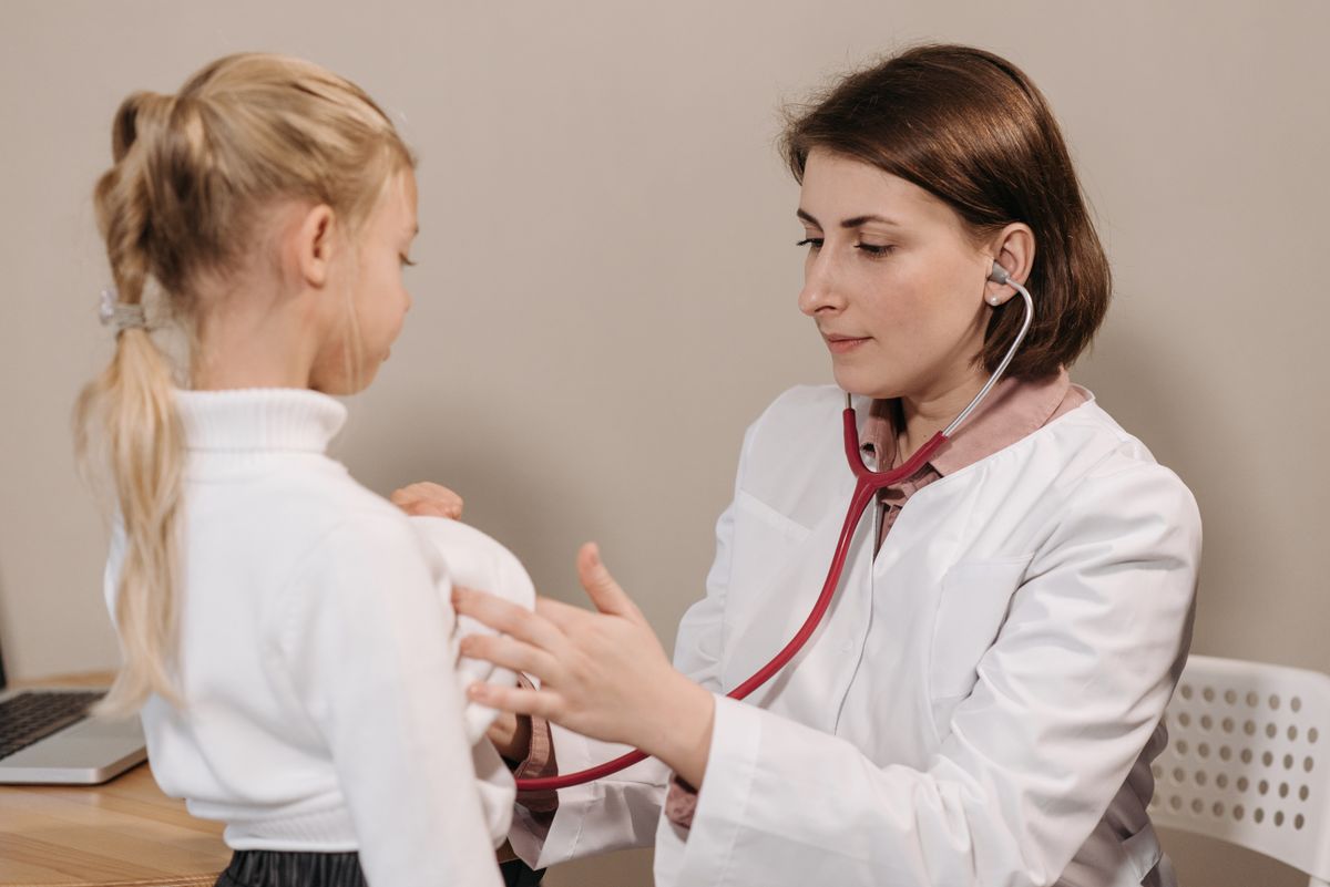 Pediatrician examining a smiling child